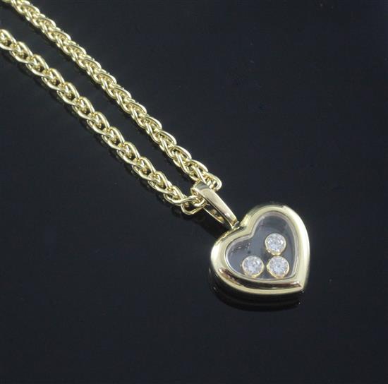 A modern 18ct gold Chopard heart shaped pendant with three floating diamonds, pendant 15mm.